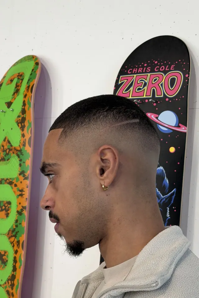 A buzz cut with a skin fade and a part line