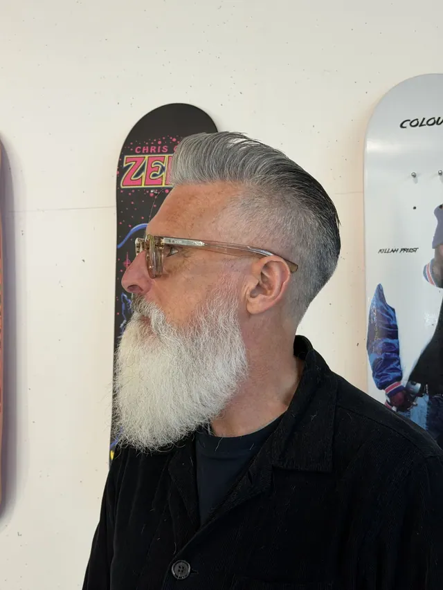 A grey slicked-back cut with a full white beard